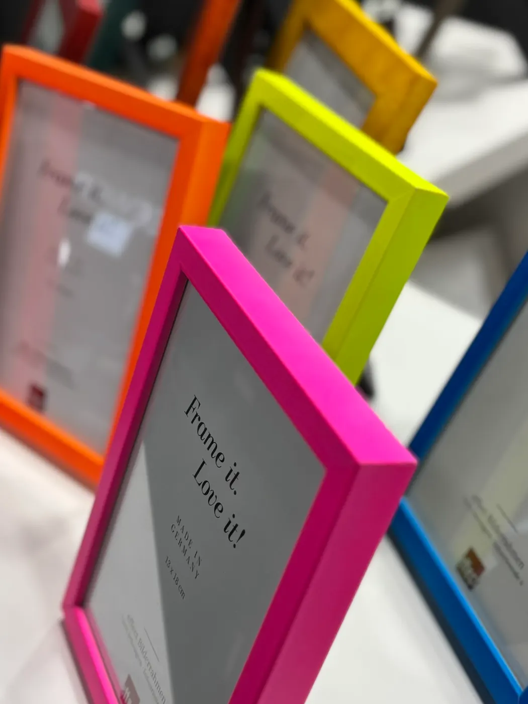 Fotolijsten in roze, neongeel, oranje en blauw van dichtbij