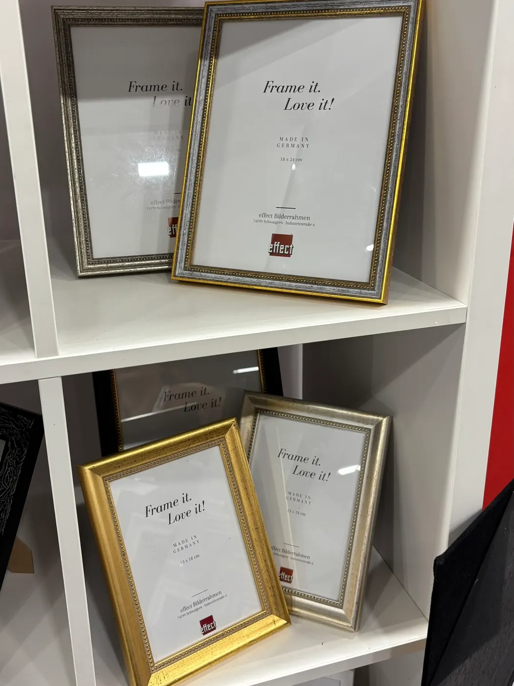 Sierlijke fotolijsten in goud en zilver in een rek op onze stand
