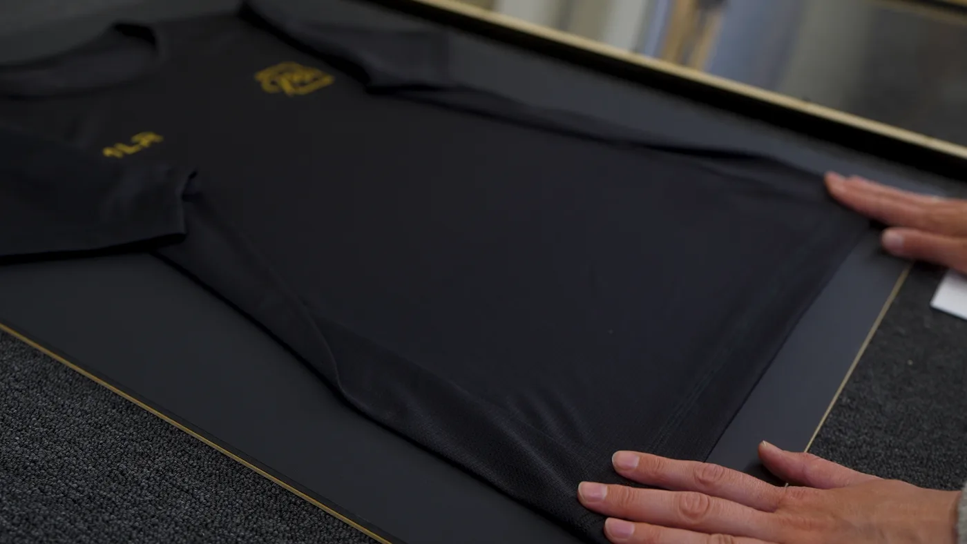 Handen strijken het shirt kreukvrij glad op de achterwand