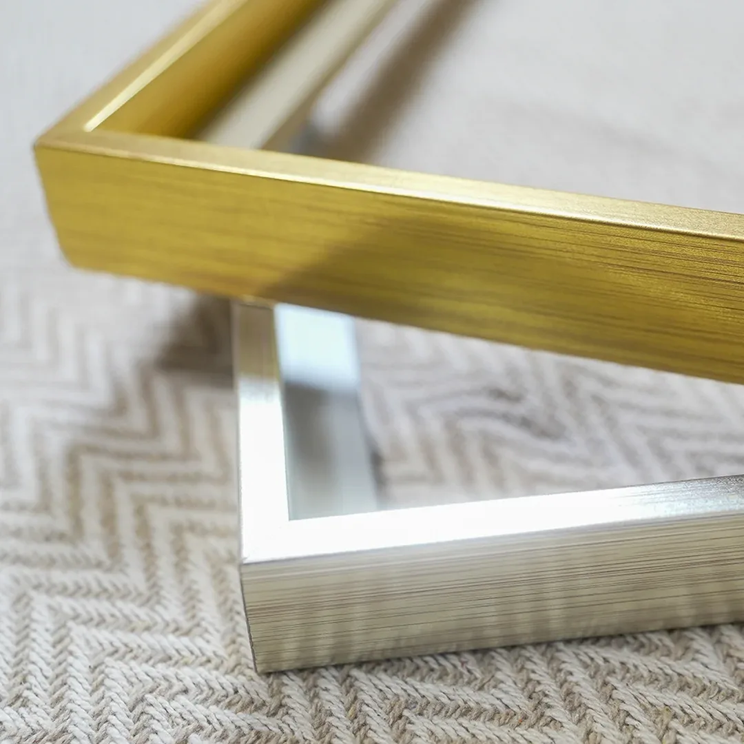 Close-up van de verstekhoeken van een gouden en een zilveren aluminium lijst