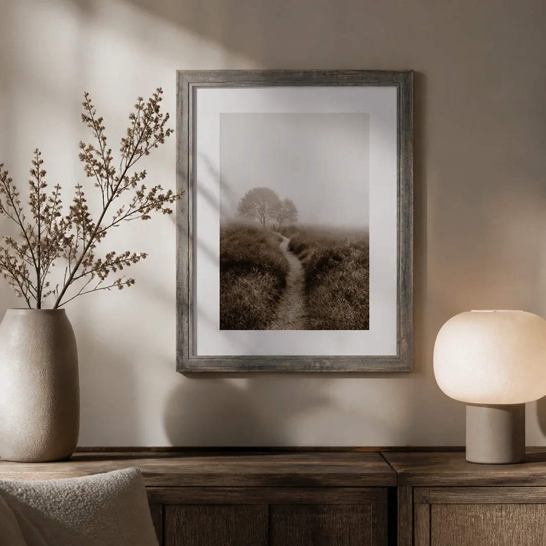 Grijs gewiste vintage lijst met landschapsfoto aan de muur boven een houten ladekast
