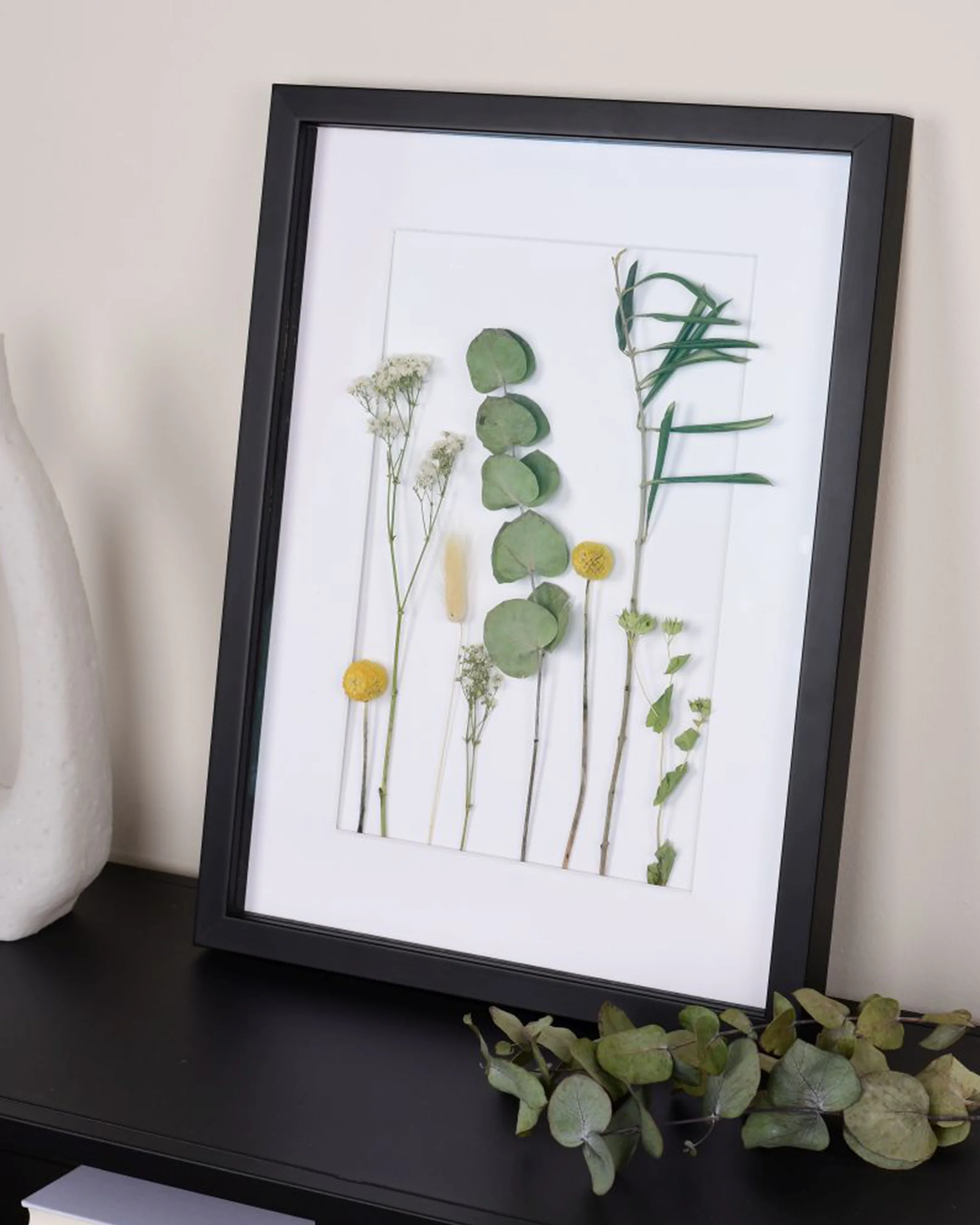 Houten fotolijst Fiona met afstandslijst zwart in een interieur