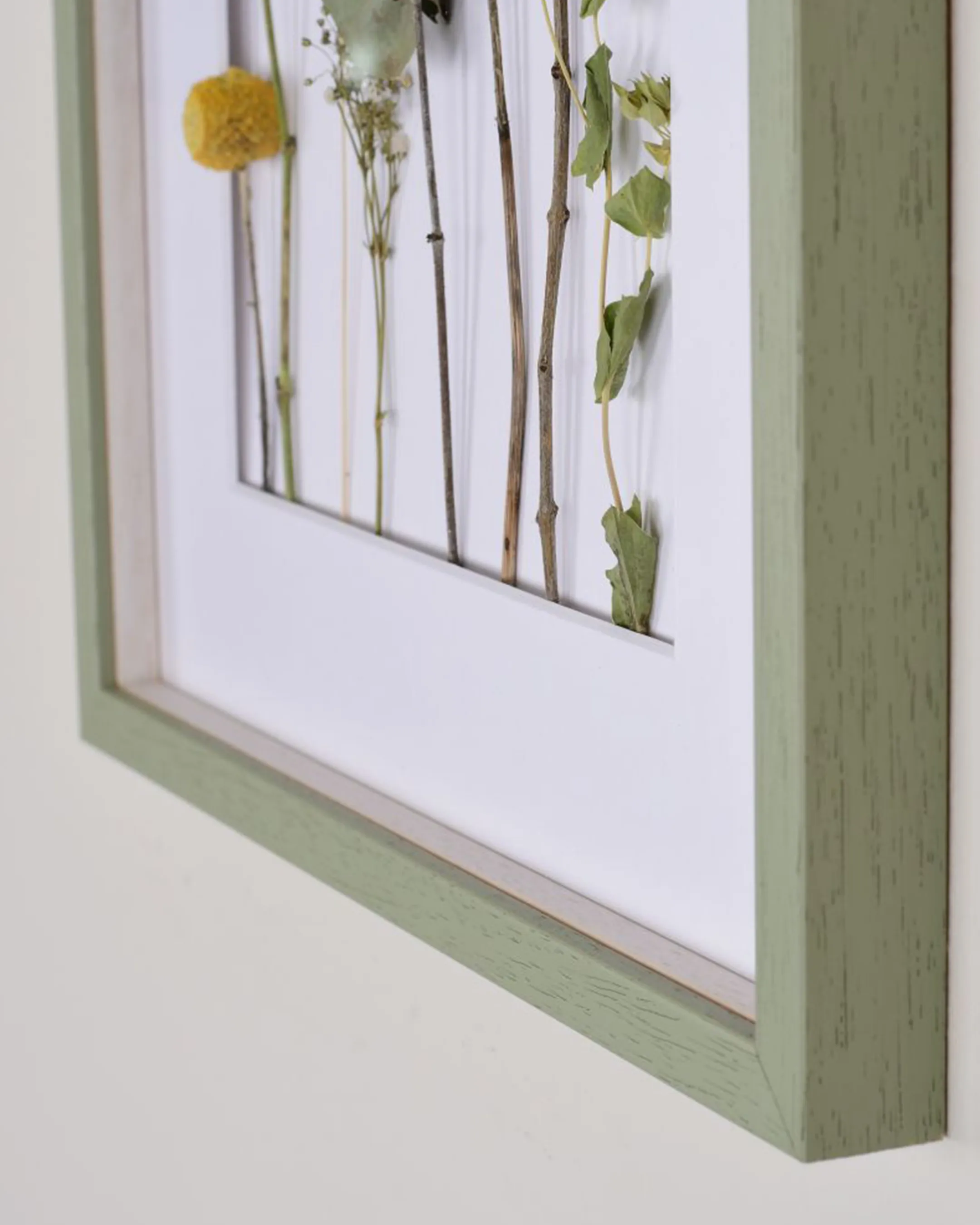 Houten fotolijst Nele met afstandslijst groen in een interieur