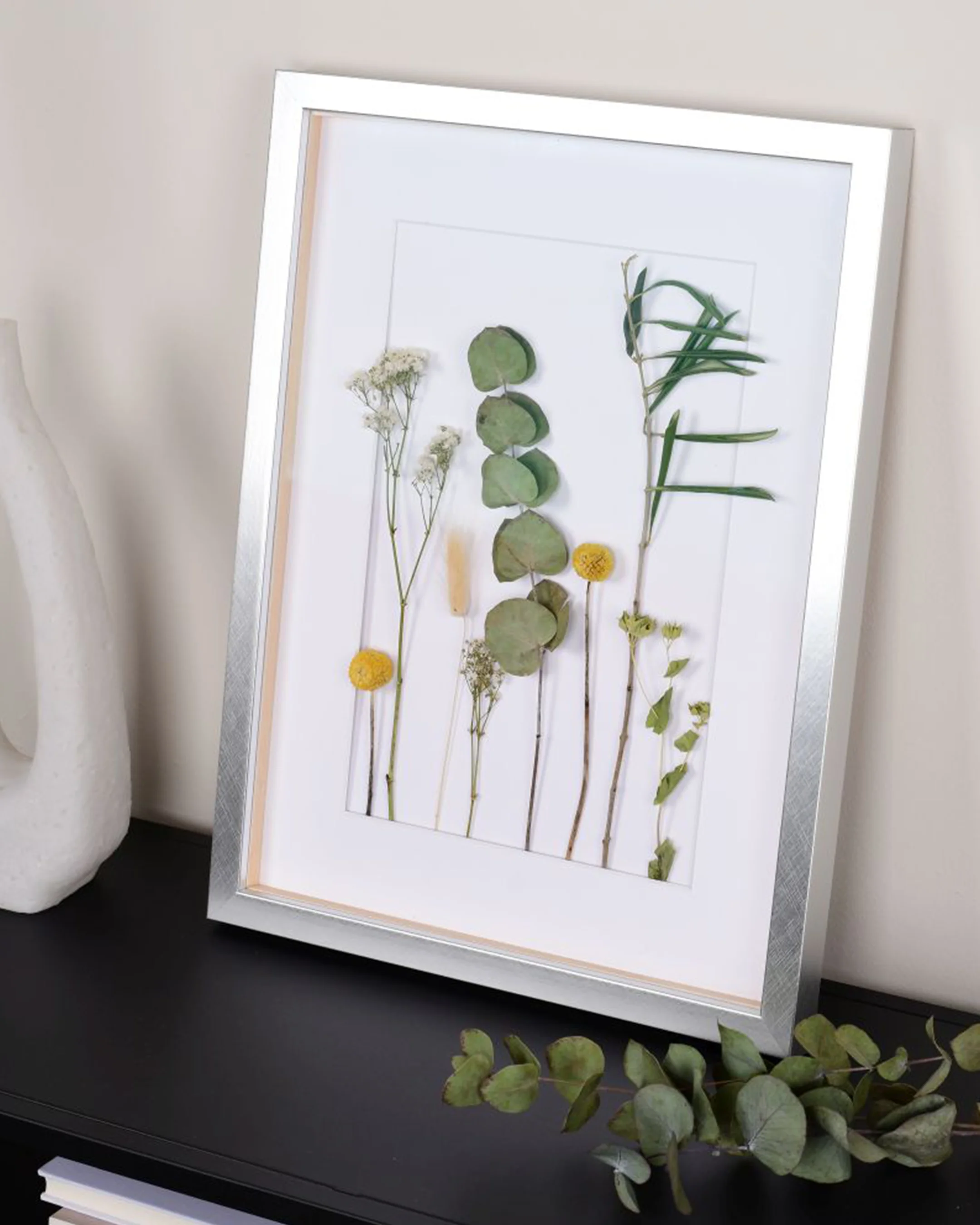 Houten fotolijst Fiona met afstandslijst zilver in een interieur