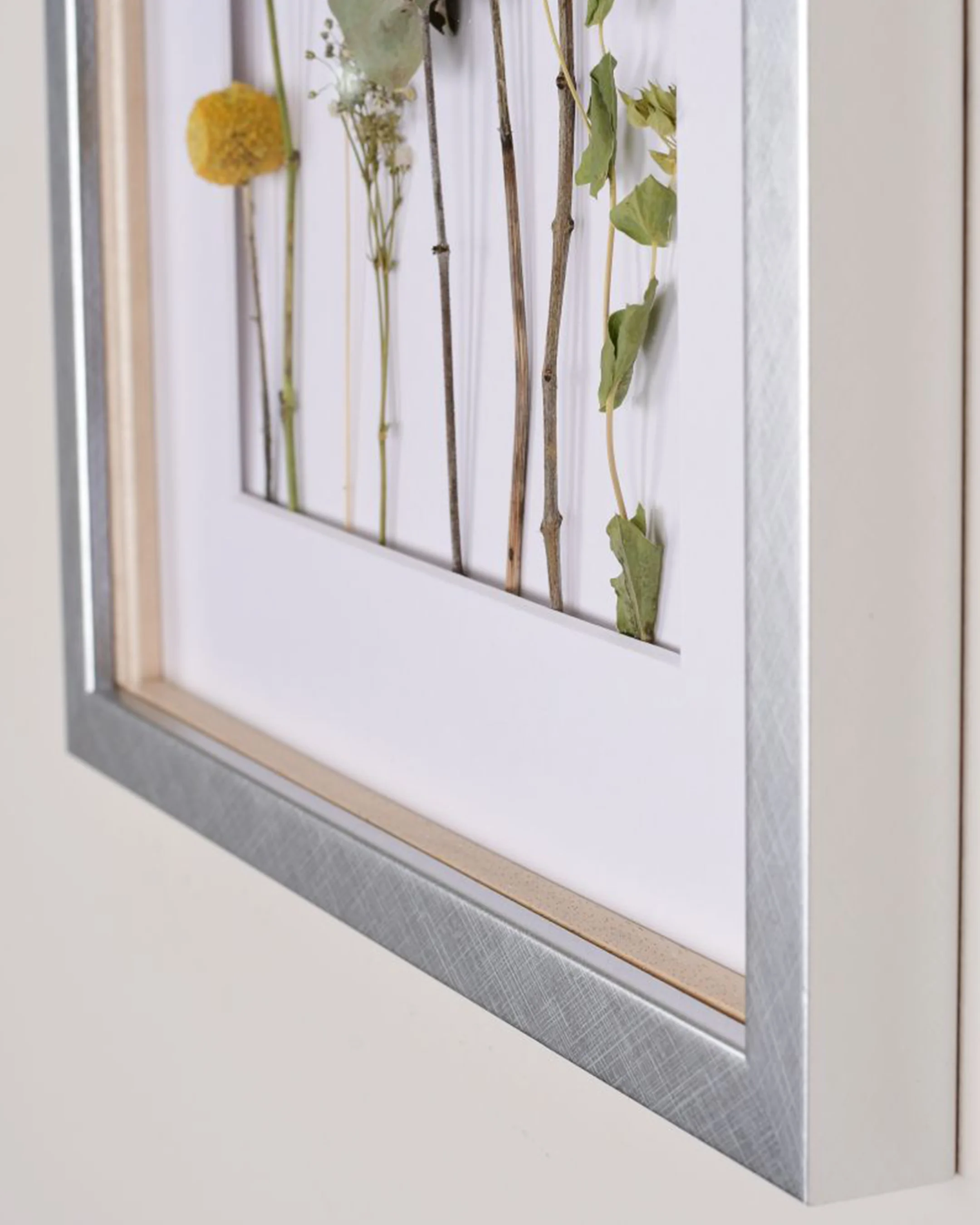 Houten fotolijst Fiona met afstandslijst zilver in een interieur
