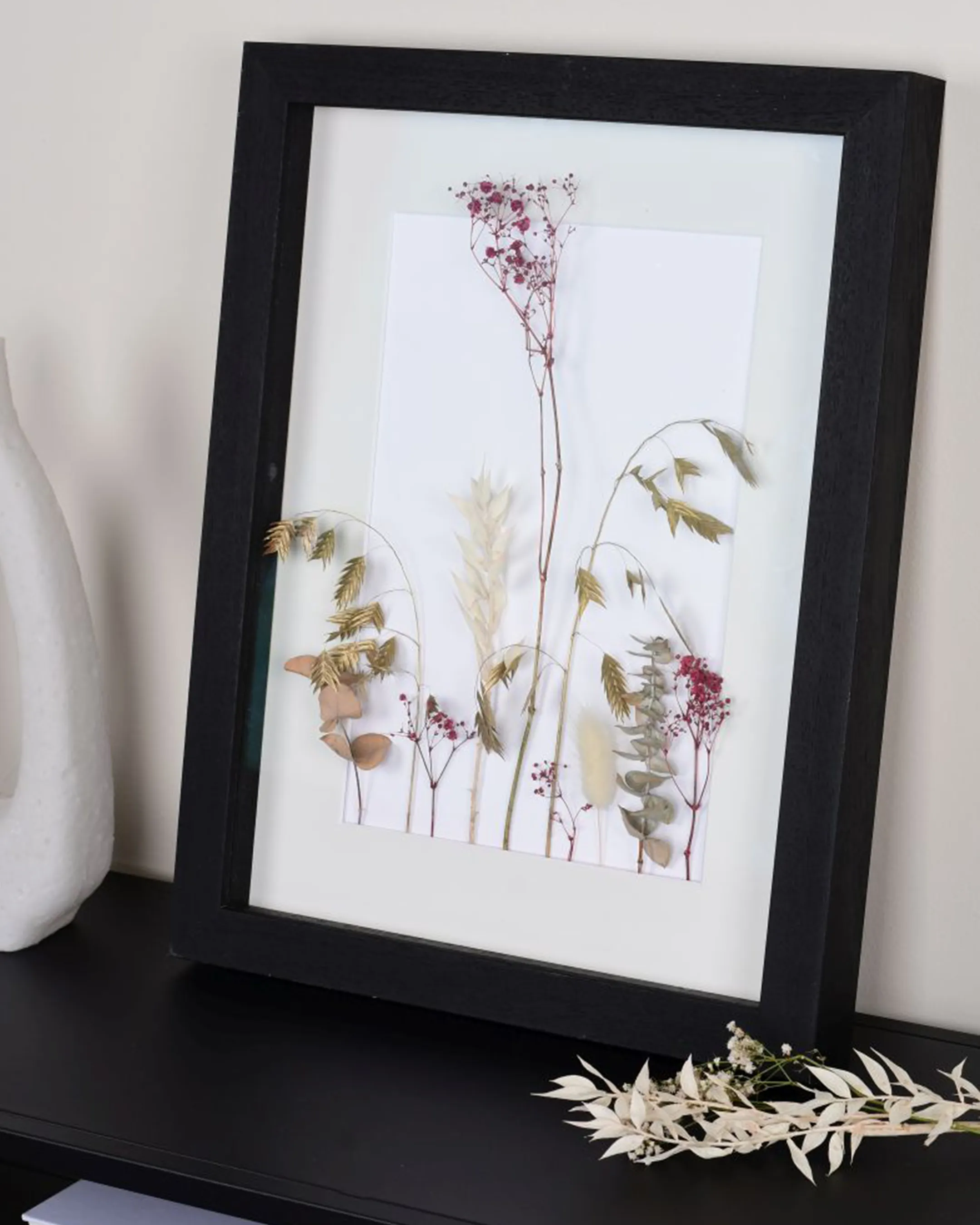Houten fotolijst Linda met afstandslijst zwart in een interieur